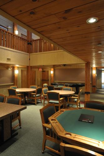 a room with tables and chairs and a pool table at POSTOAK Lodge and Retreat in Tulsa