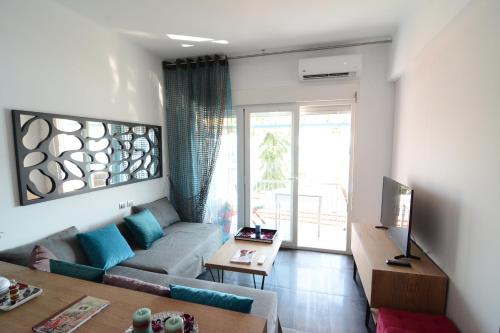 ein Wohnzimmer mit einem Sofa und einem TV in der Unterkunft Kavala marina view studio in Kavala