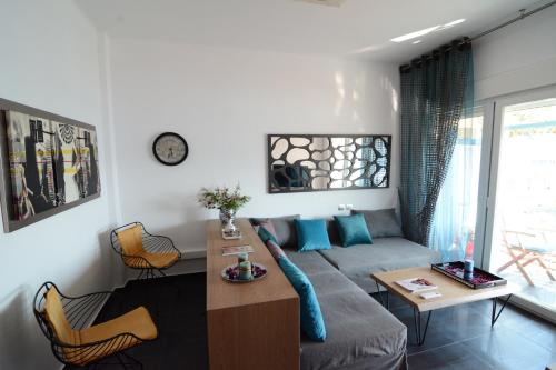ein Wohnzimmer mit einem Sofa und einem Tisch in der Unterkunft Kavala marina view studio in Kavala