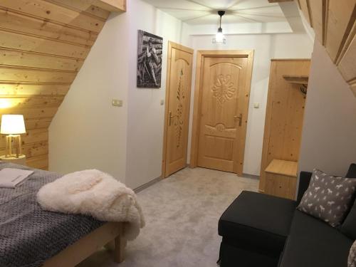a bedroom with a bed and a chair and a door at Rezydencja Kojsowka in Witów