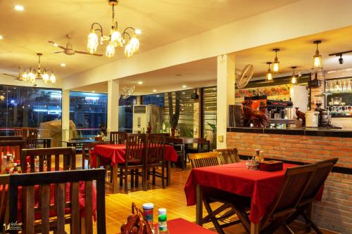restauracja ze stołami i krzesłami oraz bar w obiekcie Blossoming Romduol Boutique w Siem Reap