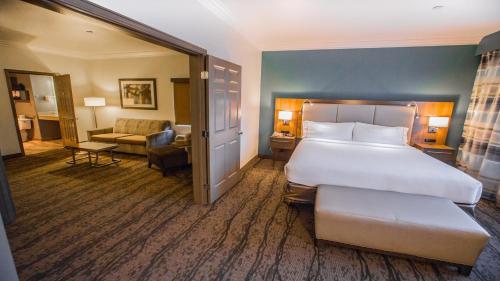a hotel room with a large bed and a living room at Holiday Inn Express Hotel & Suites - Paso Robles by IHG in Paso Robles