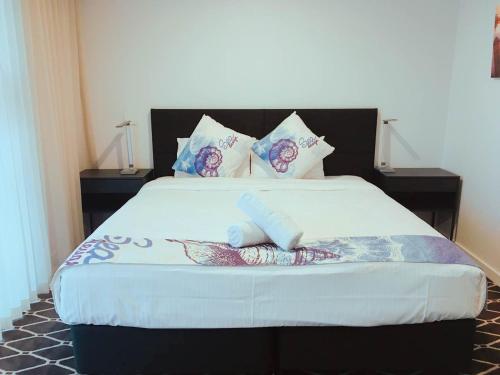 a bedroom with a large bed with pillows at ODYSSEY APOLLO BAY in Apollo Bay