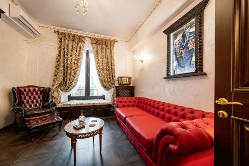 ブカレストにあるPrivate Museum Apartment with Antique Decorの赤いソファとテーブルのあるリビングルーム