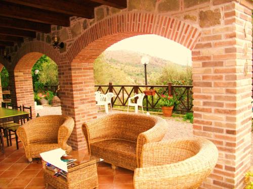 a patio with two chairs and a brick archway at L'Uliveto in Reitano