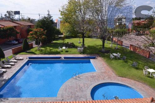 a large swimming pool in a yard next to a park at Hermosa Suite Alberca Áreas Verdes Blvd Bernardo Quintana 17D in Mendiola