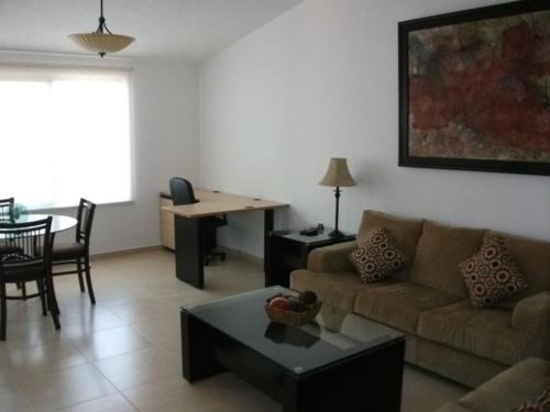 a living room with a couch and a table at Hermosa Suite Alberca Áreas Verdes Blvd Bernardo Quintana 17D in Mendiola