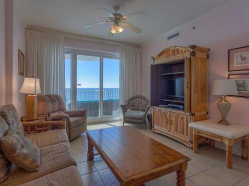 a living room with a couch and a tv and a table at Island Royale 602 in Gulf Shores