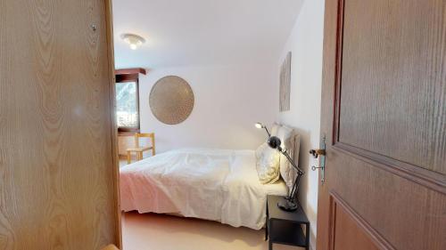 a bedroom with a bed and a desk with a lamp at Abitaziun Quadratscha 22 - Samedan in Samedan