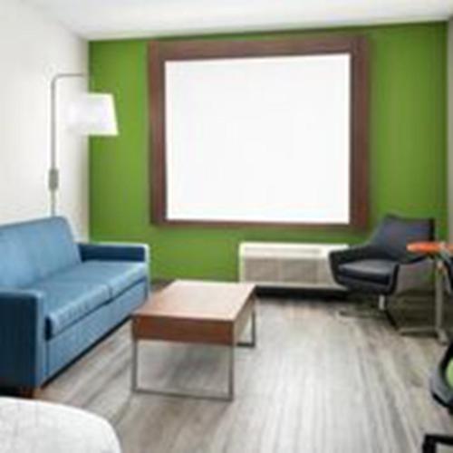 a living room with a blue couch and a table at Holiday Inn Express & Suites - Odessa I-20 by IHG in Odessa
