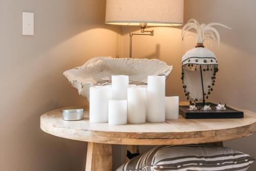 a table with a bunch of white candles on it at Luxury at Palm Beach - You've Got It Maid in Palm Beach