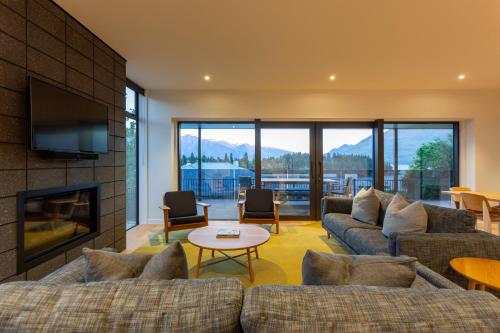 a living room with couches and a fireplace at Waipatiki by Sotheby's Luxury Rental Homes in Queenstown