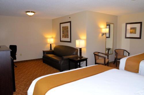 a hotel room with a bed and a chair at Cobblestone Inn & Suites - Lake View in Lake View