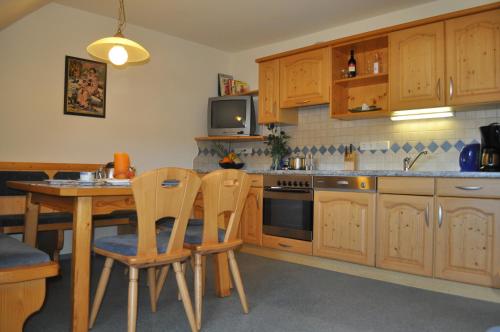 a kitchen with wooden cabinets and a table and chairs at Gappmayrhof in Tamsweg