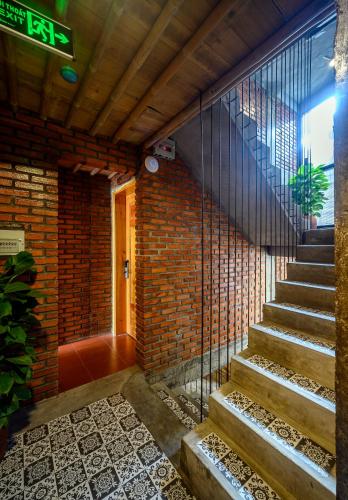 a staircase in a building with a brick wall at Mira Bãi Xếp Quy Nhơn - The Hidden Jewel in Quy Nhon