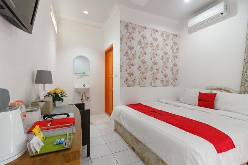 a white bedroom with a bed and a sink at RedDoorz Syariah near Exit Toll Puncak in Bogor