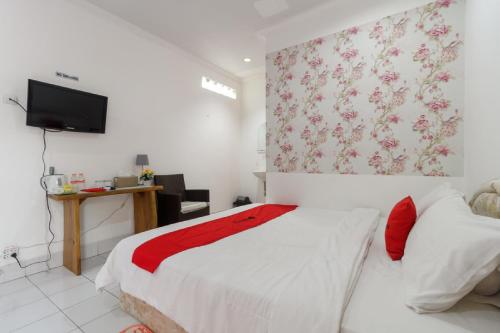 a bedroom with a bed and a tv on a wall at RedDoorz Syariah near Exit Toll Puncak in Bogor
