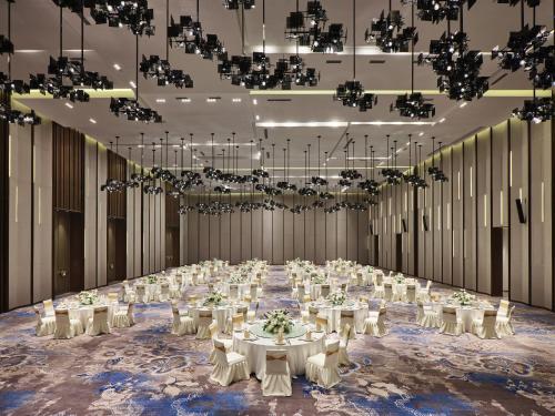 a large banquet hall with white tables and chairs at Crowne Plaza Wuhan Development Zone by IHG in Wuhan