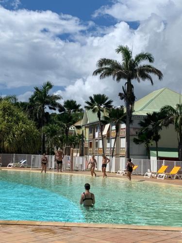 a group of people in the swimming pool at a resort at FLAMBOYANT St Francois in Saint-François