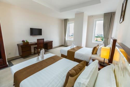 a hotel room with two beds and a television at MekongView 2 CondoTel in Phnom Penh