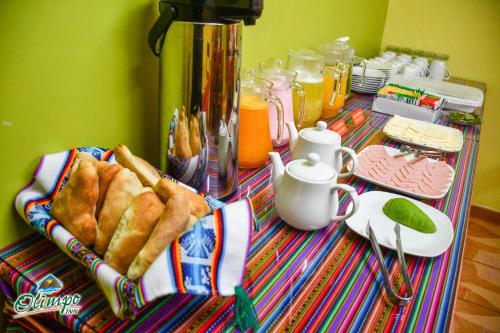 a table with pastries and orange juice on it at Olimpo Inn in Puno