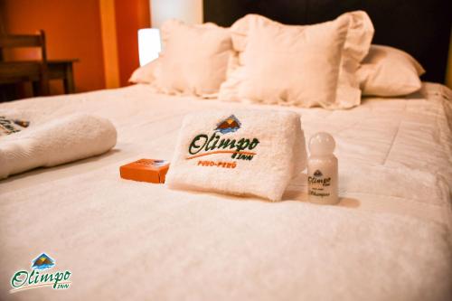 a hotel bed with a towel and a bottle of chrysler himacistacist at Olimpo Inn in Puno