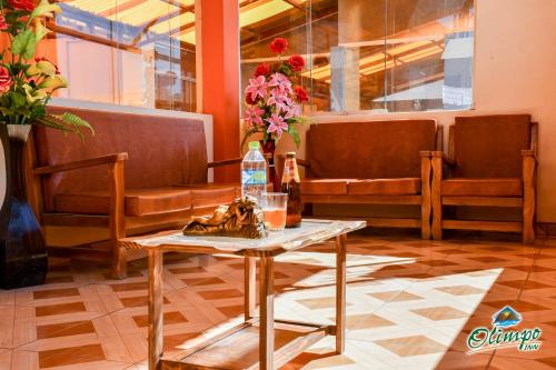 a waiting room with benches and a table and flowers at Olimpo Inn in Puno