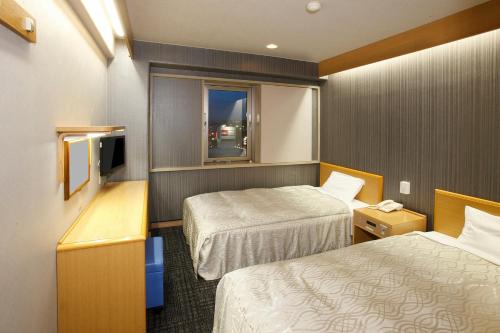 Habitación de hotel con 2 camas y ventana en Sakudaira Plaza 21, en Saku