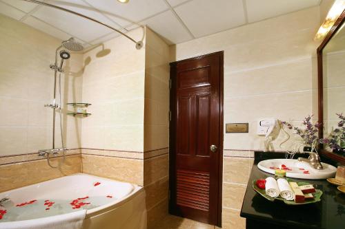 een badkamer met een bad en een wastafel bij Hanoi House Hostel & Travel in Hanoi