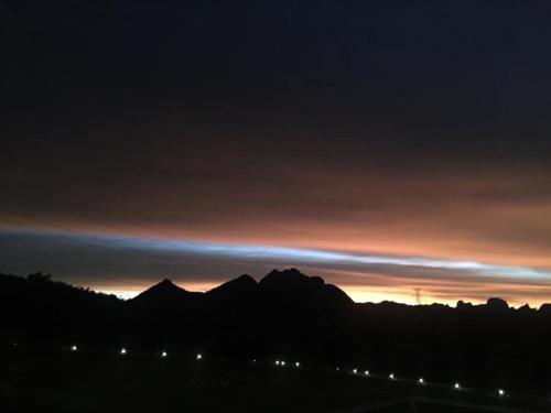 a sunset with the mountains in the background at Belong Jin The Dam Hotel And Resort in Ban Pha Saeng Lang