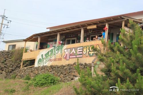 ein Gebäude mit einem Schild an der Seite in der Unterkunft Africa Guesthouse in Jeju-do