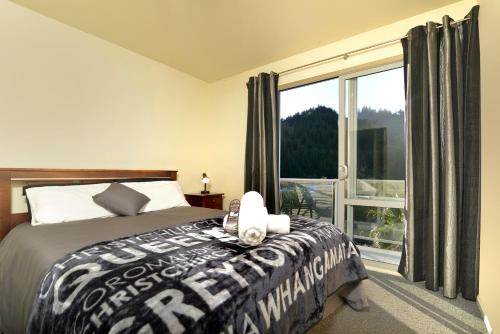 a bedroom with a bed and a large window at Tombstone Motel, Lodge & Backpackers in Picton