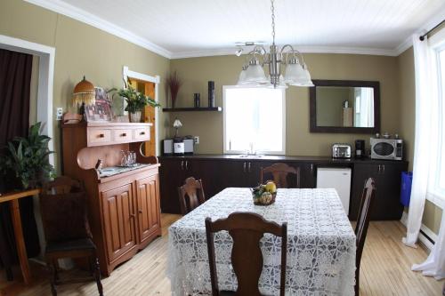 a kitchen with a table and a dining room at La Grange aux Hiboux Gîte et Restaurant B&B in La Baie