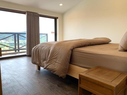 a bedroom with a bed and a large window at Garden View Villa Đà Lạt - 8 Rooms in Da Lat