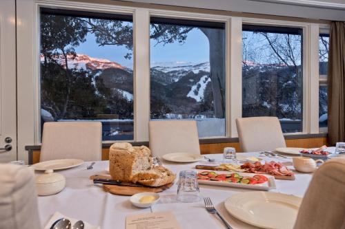 a table topped with plates of food and drinks at Pure Chalet Thredbo in Thredbo