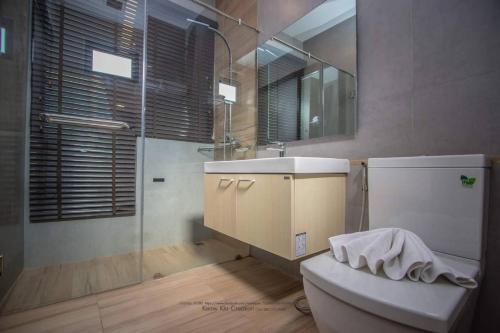 a bathroom with a toilet and a sink and a shower at Belong Jin The Dam Hotel And Resort in Ban Pha Saeng Lang