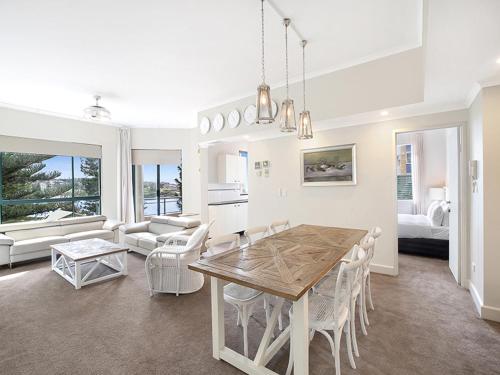 雪梨的住宿－AeA庫吉美景公寓酒店，厨房以及带桌椅的起居室。