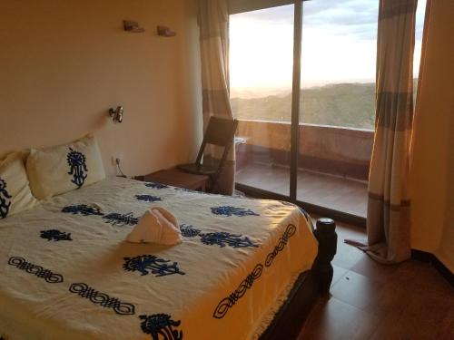 um quarto com uma cama e uma grande janela em Old Abyssinia Lodge em Lalibela