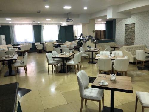 烏蘭巴托的住宿－指南酒店，餐厅设有桌子、白色的椅子和桌子以及桌面