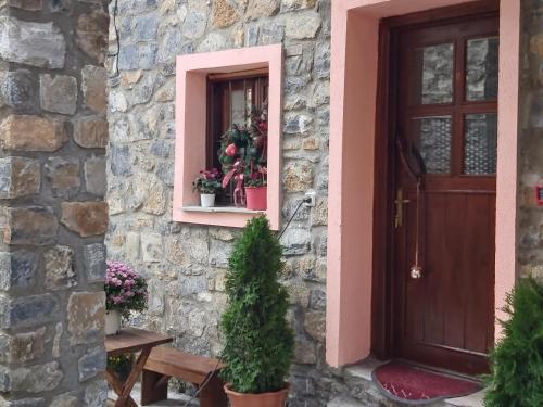 a house with a door and a window with flowers at Konaki inn in Palaios Agios Athanasios