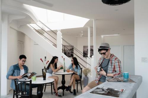 un groupe de personnes assises à des tables dans une pièce dans l'établissement Cacha Bed, à Bangkok