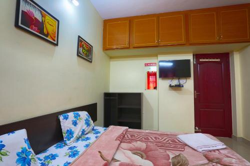a small bedroom with a bed and a red door at Skylarc Inn in Ooty
