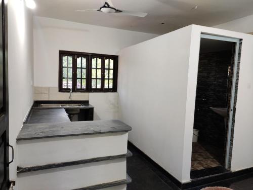 cocina con paredes blancas y encimera en Constantina Huts, en Agonda