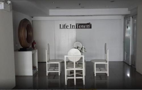 a room with two chairs and a table with a life in honour sign at Life In Town Chiangmai in Chiang Mai