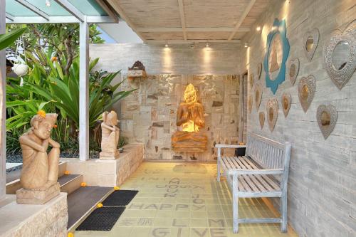 a room with a statue and a bench at Bali Cosy Villas Seminyak in Legian
