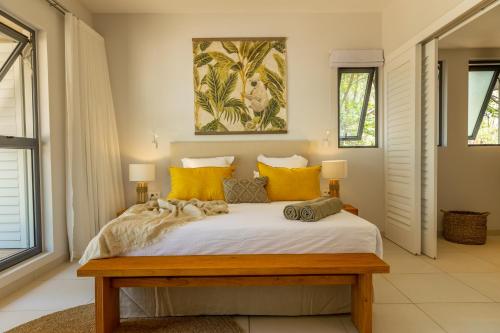 a bedroom with a large white bed with yellow pillows at Manta Cove by Horizon Holidays in Tamarin
