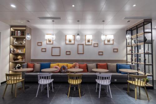 a lobby with a couch and tables and chairs at Campanile Shanghai Huaihai in Shanghai