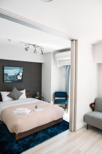 a bedroom with a large bed with a blue rug at Dash Living Nihonbashi in Tokyo