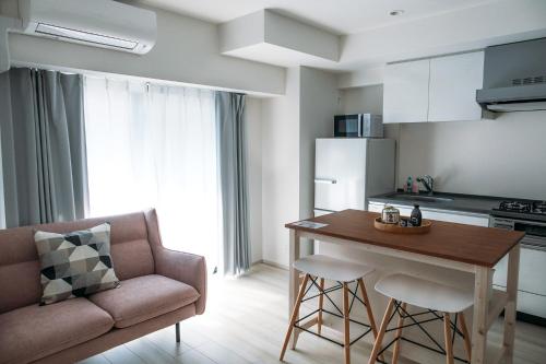 Una cocina con un sofá y una mesa en una habitación. en Dash Living Nihonbashi, en Tokio