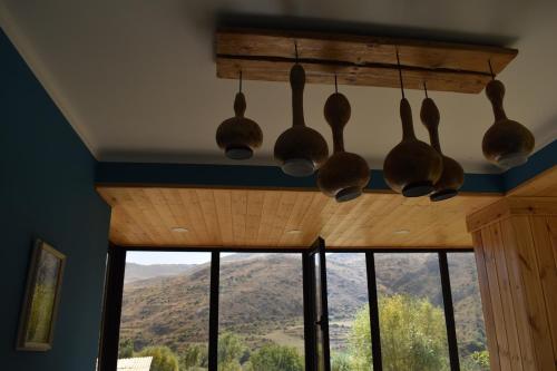 a bunch of wooden utensils hanging from a ceiling at Gnishik Eco Lodge in Gnishik